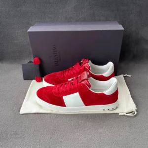 Röda Valentino flycrews - Snygga röda och vita sneakers från Valentino med en stilren design. Skorna har en vit sula och röd ovandel med vita detaljer. Perfekta för att ge din outfit en färgklick.