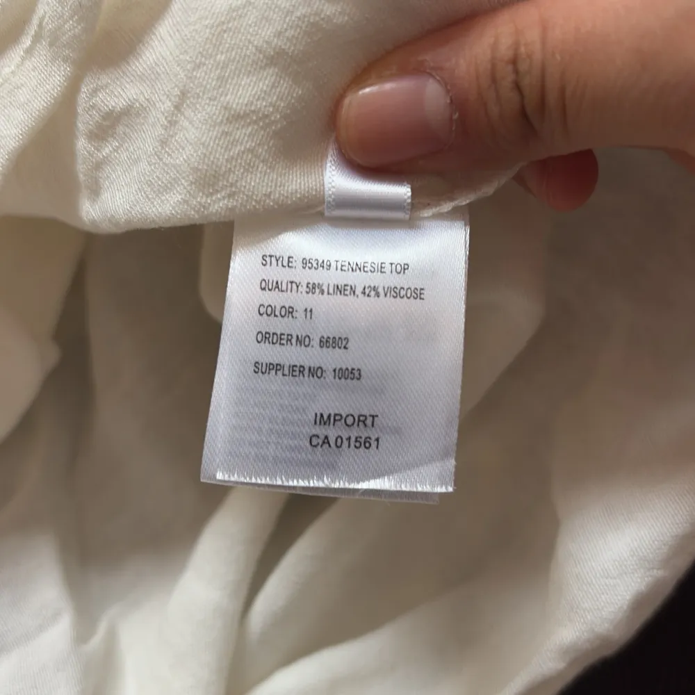 Säljer en söt vit blus från co'couture med korta ärmar och en smockad halsringning. Blusen har en avslappnad passform och är perfekt för varma dagar. Den är tillverkad i ett lätt och luftigt material. . Yläosat.