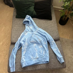 Ljusblå hoodie från Calvin Klein - Säljer en snygg ljusblå hoodie från Calvin Klein Jeans. Den har en stor logga på baksidan och en praktisk magficka framtill. Använd fåtal gånger. Frakt tillkommer.