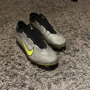Nike Zoom Mercurial Vapor 15 Elite - Snygga fotbollsskor från Nike i silverfärg med svarta och gula detaljer. Skorna är väldigt snygga och väll omhändertagna, kan gå ner i pris vid smidig och snabb affär🌟🌟