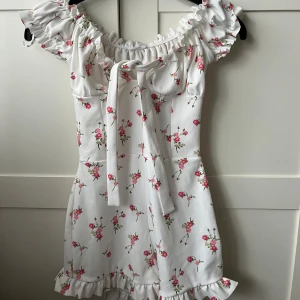 Vit blommig klänning från Missguided - Vit blommig klänning från Missguided i storlek XS/S. Prislappen är kvar, Aldrig använd och har inga fläckar eller märken!