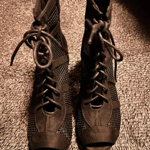 Dansboots - Snygga svarta boots med snörning och klack (ca 7cm). Skorna har ett nätliknande mönster och är tillverkade i mocka. Perfekta för en trendig look.