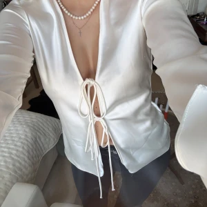 Vit satinblus med knyt  - Elegant vit blus i satin från Zara med knytning framtill. 