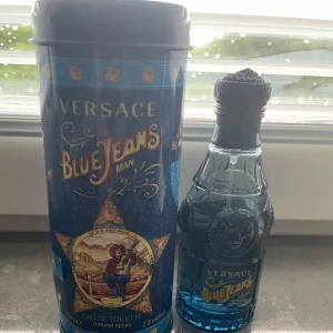 Versace Blue Jeans Man Eau de Toilette - Versace Blue Jeans Man är en ikonisk herrparfym med fräsch och maskulin doft. Flaskan är blå och har en unik design med detaljer i relief, och kommer i en dekorativ metallburk med western-inspirerat motiv.