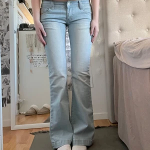 Ljusblå lågmidjade jeans - Utsvängda/flared jeans med väldigt låg midja! Använda 2 gånger, så väldigt fint skick. Mått = midja: 41cm, innerbenslängd: 83cm, från skrevet och upp: 19cm ✌🏼Storlek 29, motsvarar S.