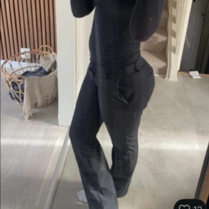 Bikbok kostymbyxor - Snygga svarta kostymbyxor med klassisk rak passform och pressveck. Byxorna har fickor i sidorna och hällor för bälte. Perfekta för en stilren och uppklädd look.