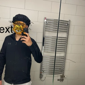 Svart träningsjacka från Under Armour - Säljer en svart träningsjacka från Under Armour med dragkedja framtill. Jackan har lång ärm och en sportig look, perfekt för träning eller vardagsaktiviteter. Klassisk logga på bröstet och smidig passform.