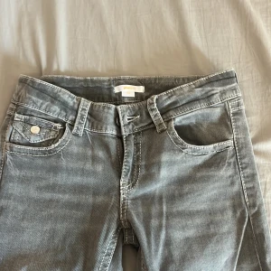 Grå jeansbyxor från Gina Tricot - Säljer ett par grå jeansbyxor från Gina Tricot i storlek 158. Byxorna har klassisk femficksdesign, och synliga vita sömmar. Perfekta för dig som gillar en enkel och stilren look.
