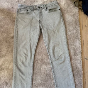 Ljusgrå Levi's 511 jeans - Säljer ett par ljusgrå Levi's 511 jeans med klassisk femficksdesign och raka ben. Jeansen har normal passform och är tillverkade i denim med knapp- och dragkedjegylf. 