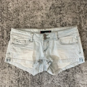 Ljusblå jeansshorts från Tally Weijl - Säljer ett par ljusblå jeansshorts från Tally Weijl med låg midja, midjemåttet är 39cm 😇😙 Shortsen har två knappar framtill. Perfekta för varma dagar och enkel att matcha 🥰(dom två sista bilderna är ej på mig utan tjej jag köpte dom från) 