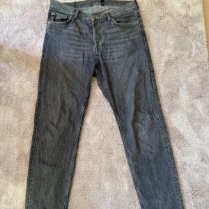 Grå jeans från Weekday - Säljer ett par klassiska grå jeans från Weekday, modellen heter Barell, med raka ben. Jeansen har normal passform och stängs med knappar. Höger framficka är trasig men inget som syns vid användning 
