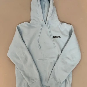 Ljusblå hoodie från Shelta med tryck - Stl S men passar M också. Tröjan kostade 1200kr orginalpris, använd 2 gånger. 
