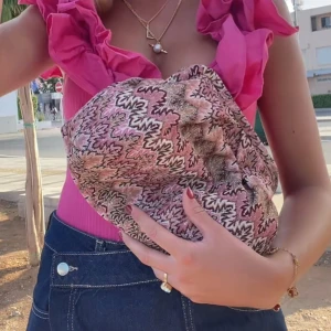 Mönstrad kuvertväska i rosa och svart - Säljer en kuvertväska med unikt mönster i rosa, svart och beige. Väskan har en mjuk form och är perfekt att bära under armen. Materialet känns som syntet och väskan har en cool, trendig vibe.