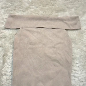 Beige offshoulder topp - Säljer en beige offshoulder topp som sitter tight. Perfekt för dig som gillar en enkel men snygg stil. Toppens material känns mjukt och stretchigt.