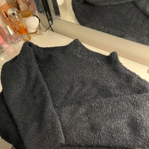 Mörkgrå fluffig tröja - Säljer en mysig mörkgrå gillter tröja med fluffig textur. Perfekt för kyliga dagar när du vill hålla dig varm och bekväm. Tröjan har långa ärmar och en normal passform🤍