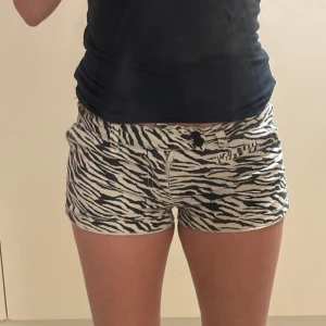Zebramönstrade shorts från Bik Bok - Snygga zebramönstrade shorts från Bik Bok i svart och vit. Perfekta för sommaren med en normal passform och låg midja. De har knappar framtill och är gjorda i ett bekvämt material. Har ni frågor är det bara och skriva!💗