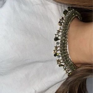 Guldhalsband med stjärndetaljer - Snyggt guldhalsband med hängande stjärnor och droppformade detaljer. Perfekt för att ge en glittrig touch till din outfit. Justerbar kedja för perfekt passform. så bra kvalitet på detta halsbandet och älskar de gröna kristallerna på.