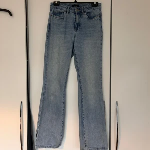 Blå bootcut jeans - Snygga blå bootcut jeans med klassisk femficksdesign. Perfekta för en avslappnad stil. De har en hög midja och en lätt utsvängd passform som ger en retro känsla.