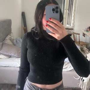 Svart ribbad croppad tröja - Säljer en svart ribbad croppad tröja med långa ärmar och snygg snörning i ryggen.