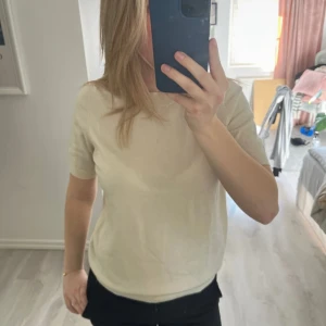 Beige kortärmad topp - Säljer en stilren beige topp med korta ärmar. Perfekt för en avslappnad look. Passar bra till både jeans och kjol.