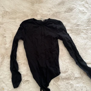 Svart body från Nelly - En svart body från Nelly i storlek Xs/s. Sitter figurnära och väldigt snyggt