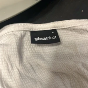 Vit knytblus från Gina Tricot - Köpte denna förra veckan men det var helt enkelt inte för mig då jag vill börja ha täckande kläder orginallpris 299 men säljer för 200 men pris kan diskuteras💕💕tveka inte om att fråga om en bättre bild 😚😚 OBS SÄLJER OCKSÅ I FÄRGEN SVART _______________________________________________Säljer en stilren vit blus från Gina Tricot Texturerad topp med knytning bak. Toppen är vit och har v-ringning. Den har normal passform, utsvängd ärm och rynkningar under bysten ORGINALLPRIS 299 