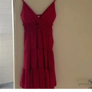 Rosa klänning med smala axelband - Säljer en söt rosa klänning med smala axelband och v-ringning. Klänningen har en elastisk midja och volanger som ger en fin form. Perfekt för varma dagar! Står ingen st men passar mig som har S/M ❤️ ❗️FRI FRAKT❗️