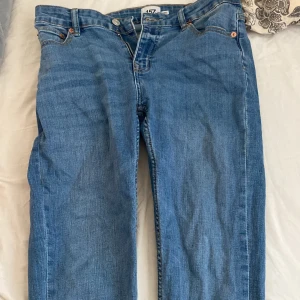 Blå jeansbyxor - Säljer ett par klassiska blå jeansbyxor med normal passform. De har en traditionell femficksdesign och är tillverkade i slitstarkt denim. Perfekta för en avslappnad stil.