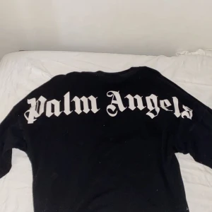 Svart tröja från Palm Angels - Säljer en svart tröja från Palm Angels med stort tryck på ryggen. Tröjan har långa ärmar och en avslappnad passform. Originalpris: 235