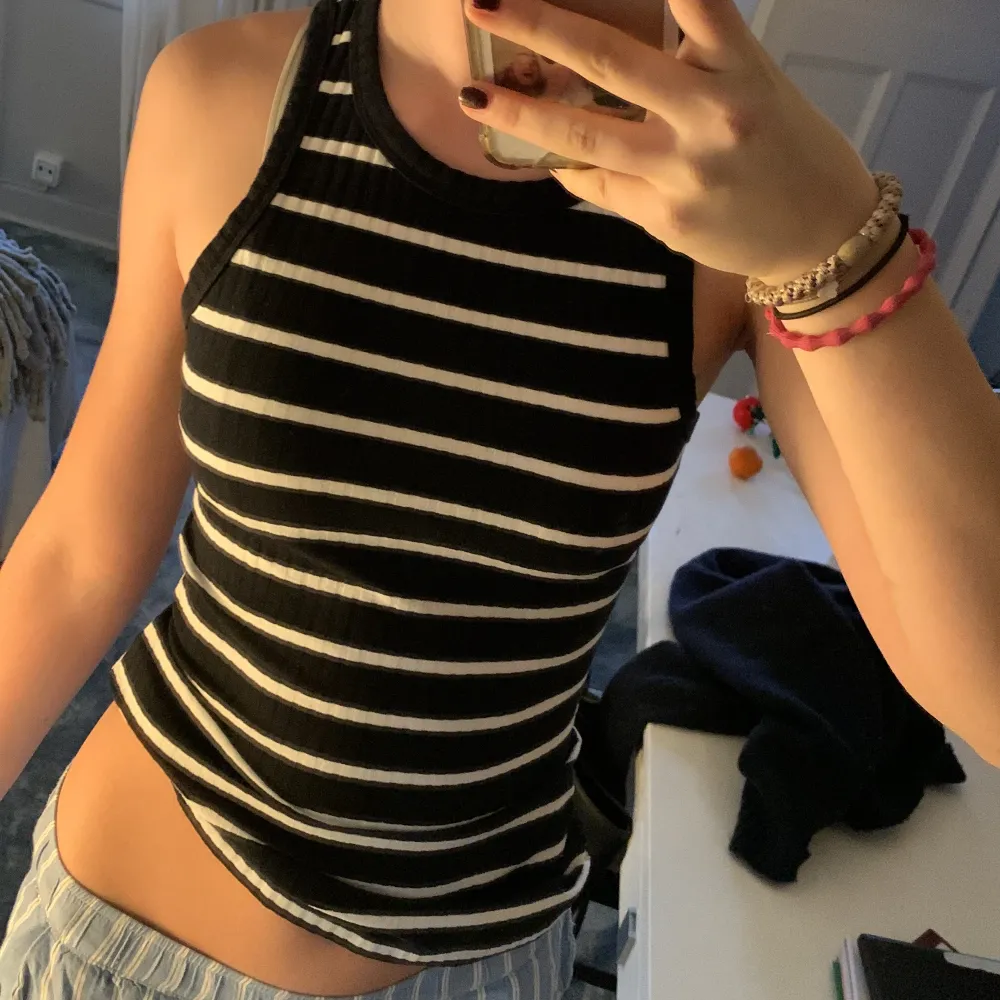Snygg svartvitrandig linnetopp från Twist & Tango. Toppen har ett ribbat mönster och är ärmlös, perfekt för en stilren look. Passar bra till både jeans och kjol.. Yläosat.