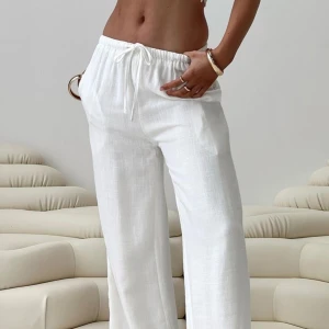 Vita linnebyxor med snörning - Denna stiliga linnebyxa är helt ny och aldrig använd, perfekt för sommarens alla tillfällen. Med sitt lätta och luftiga material ger den både komfort och stil, oavsett om du är hemma eller på resande fot. 	•	Material: 100% linne – svalt och bekvämt för varmare dagar. 	•	Passform: Mjuk och ledig passform för rörelsefrihet och komfort. 	•	Design: Klassisk och stilren, lätt att matcha med olika toppar och skjortor. 	•	Originalpris: 500 kr – nu till ett bra pris!