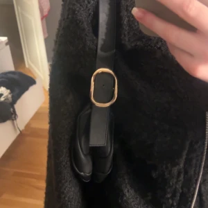 Svart väska - Svart väska i skinn material och guldigt spänne💛