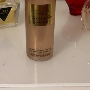 Bare Vanilla Shimmer från Victoria's Secret - Säljer en flaska Bare Vanilla Shimmer från Victoria's Secret. Denna doftspray har en härlig vaniljdoft med inslag av mjuk kashmir och ger en skimrande effekt på huden. Flaskan rymmer 250 ml och är perfekt för att ge en lyxig känsla till vardags.