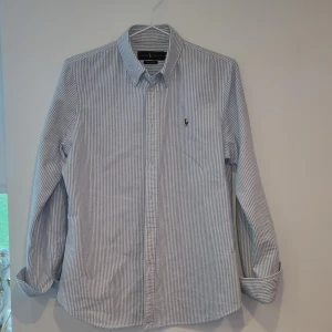 Randig skjorta från Ralph Lauren - Tjena, säljer nu min Ralph Lauren skjorta i nyskick. Den är typ inte använd och har inga defekter. Perfekt nu inför sommaren. Köpt för cirka 1500kr och säljer för bara 599! Bara att höra av sig kring funderingar.