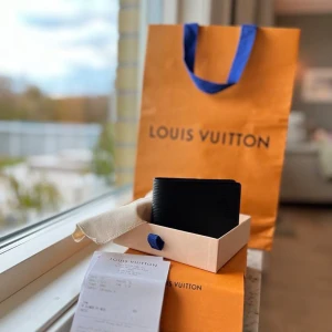 Louis Vuitton-plånbok – Oanvänd i originalförpackning - Säljer en stilren och exklusiv Louis Vuitton-plånbok i nyskick. Nypris uppskattas till ca 5 500 kr. Plånboken är helt oanvänd och levereras med allt originalinnehåll: box, påse och kvitto. Observera att boxen har en mindre fläck, vilket framgår på bilden.  Perfekt för den som söker en tidlös accessoar med lyxig design.  Skicka gärna ett meddelande vid frågor eller intresse!
