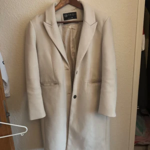 Kappa beige  - Säljer min kappa då jag inte trivs med att det är såpass lång. Använd under hösten 2024 ser knappt använd ut och är hel och fin. Väldigt varm och skön funkar i nästan alla väder. Storlek 38 köpte den för 950kr på new Yorker 