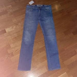 Blå slim fit jeans från Jacob Cohén - Säljer ett par klassiska blå jeansbyxor från Jacob Cohén med raka ben och femficksdesign. Jeansen är slim fit och perfekta för den som vill klä sig exklusivare. Den ljusare blåa färgen gör de perfekta för sommaren.                                                Skriv vid minsta frågor så som äktenhets verifiering. Pris ej hugget i sten❗️ 