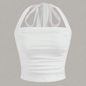 Vit croppad halterneck topp med knyt - Snygg vit croppad halterneck topp med knyt i nacken. Toppen har en tight passform och är perfekt för varma dagar. Tillverkad i mjukt material som sitter skönt mot kroppen.