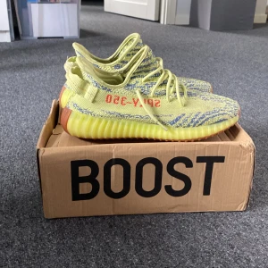 Adidas Yeezy Boost 350 V2 'Semi Frozen Yellow' - Säljer ett par Adidas Yeezy Boost 350 V2 'Semi Frozen Yellow'. Lådan ingår men den är inte i bra skick då den har stått underst i en skolådshög länge skorna är i bra skick men lite smutsiga