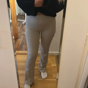 Beige tighta bootcut byxor - Säljer ett par beige tighta byxor med bootcut passform. Byxorna har hög midja och är gjorda i ett stretchigt material som sitter skönt på kroppen. Perfekta att styla med en crop top eller hoodie.