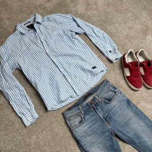 Blåvit randig skjorta från Scotch & Soda - Säljer en klassisk blåvit randig skjorta från Scotch & Soda. Storlek L, köp för endast 199.