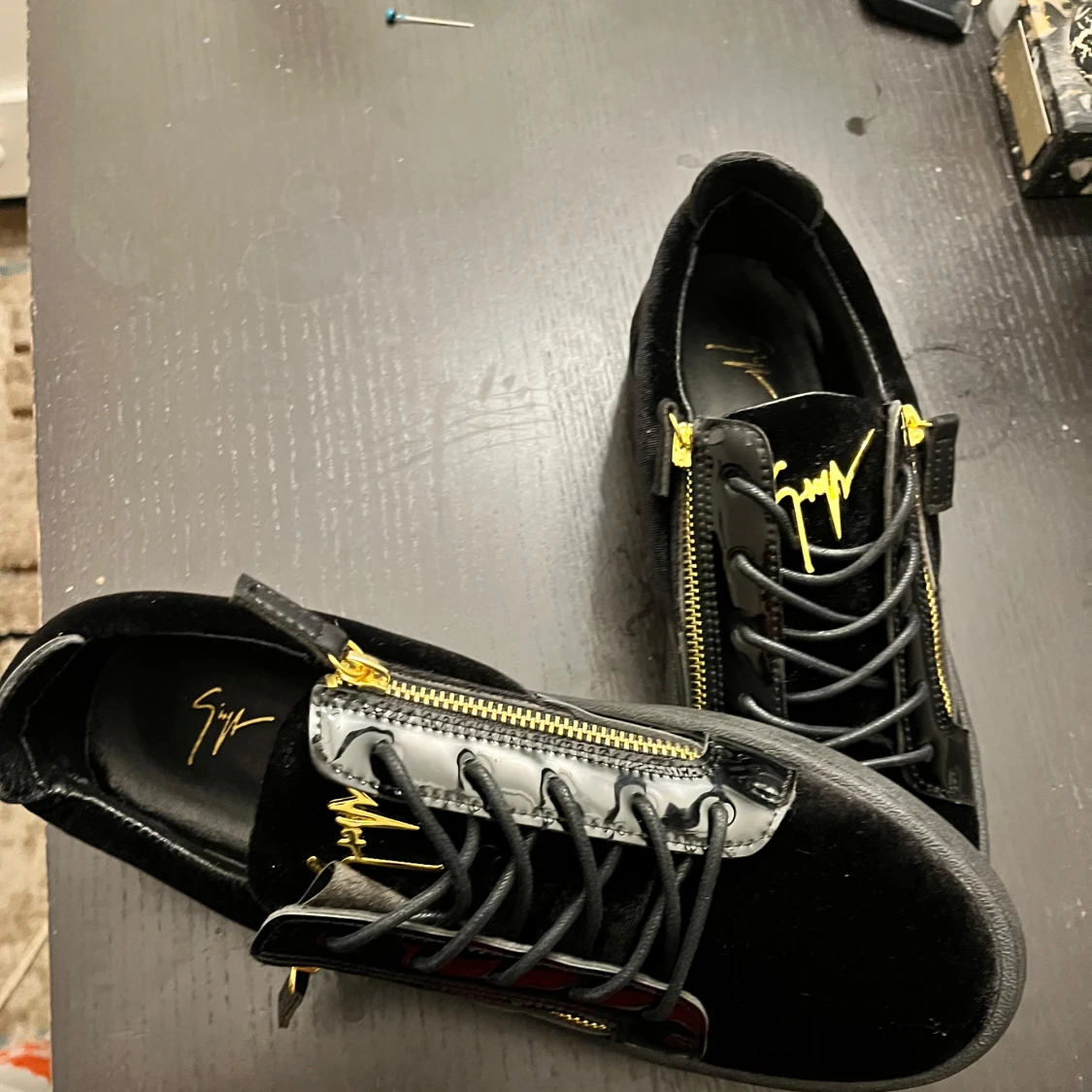 Svarta sneakers från Giuseppe Zanotti med gulddetaljer