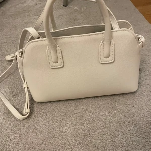 Vit/beige väska från mango - Säljer en stilren vit axelväska med både handtag och axelrem. Helt ny❤️❤️