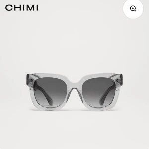 Grå solglasögon från CHIMI - Stilrena solglasögon från CHIMI med transparent grå båge och svarta tonade glas. Rektangulär form som ger en modern vibe. Perfekta för att lyfta din look under soliga dagar. Den är använd max 5 gånger. Ny duk. Box tillkommer. Buda😊