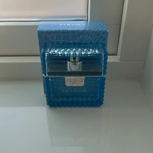 Versace Man Eau Fraîche EdT 50ml i nyskick  - Fräsch och maskulin parfym från Versace i en blå, mönstrad glasflaska. Eau Fraîche-varianten har en lätt, akvatisk doft och levereras i en snygg förpackning med silverdetaljer. Perfekt för dig som gillar exklusiva och moderna dofter.