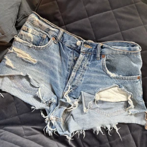 Blå slitna jeansshorts från Zara - Snygga blå jeansshorts från Zara med slitna detaljer och fransig kant. Använt mycket men fortfarande fint skick 