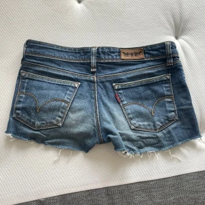 Assnygga Levis jeansshorts😻 - Säljer ett par klassiska blå jeansshorts från Levi's. Shortsen har låg midja. Perfekta för varma dagar och enkel att matcha. 37cm midjemått rakt över💓