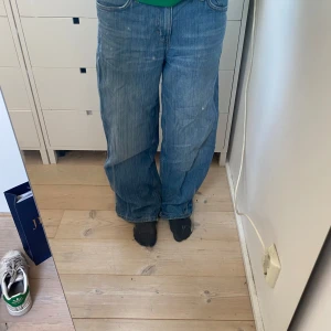 Blå baggy jeansbyxor weekday - Säljer ett par blå jeansbyxor med baggy passform från weekday. Klassisk modell med låg midja och diskreta slitningar för en avslappnad look. Perfekta för dig som gillar en loose och bekväm stil. Köpte för 500kr