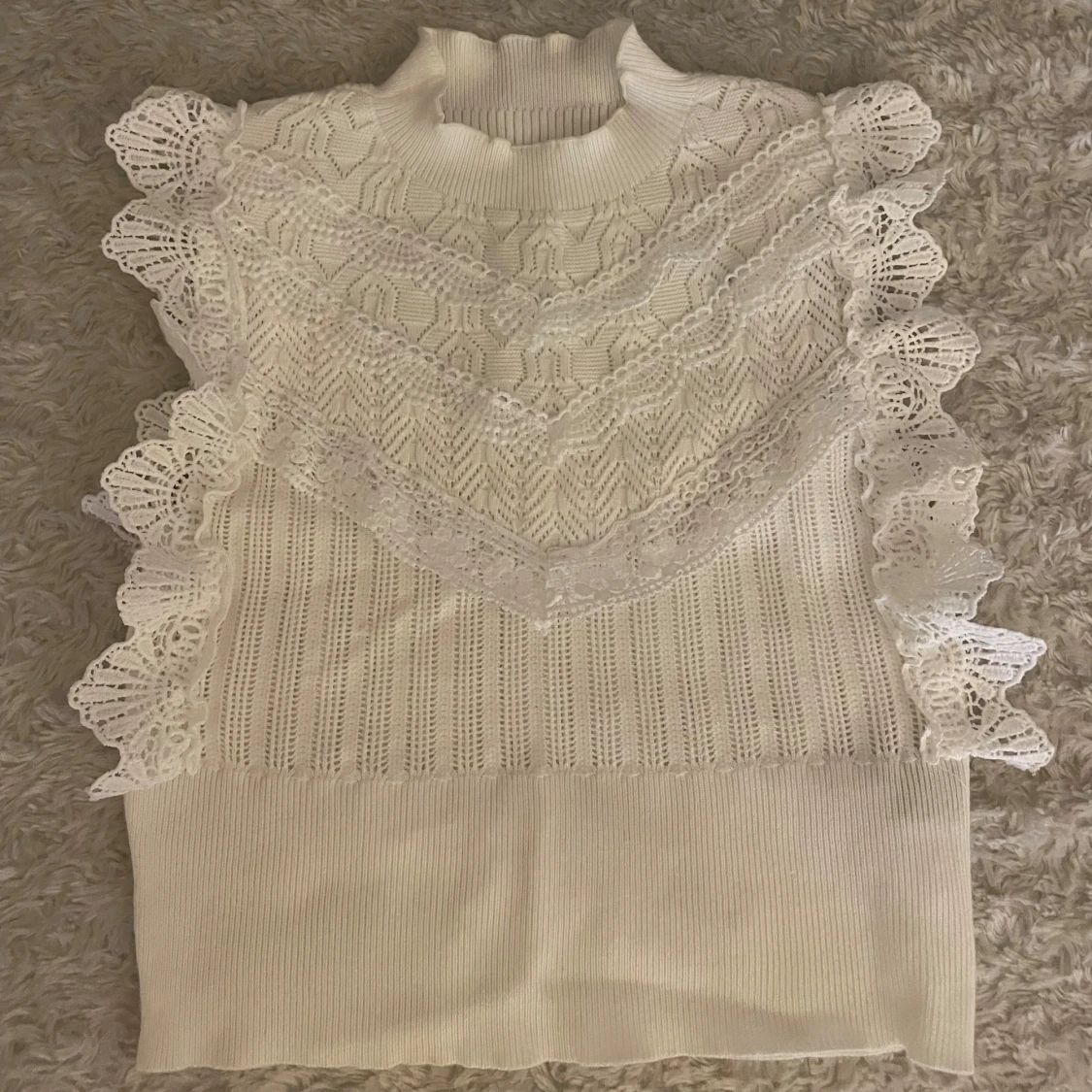 Vit stickad topp med spetsvolanger