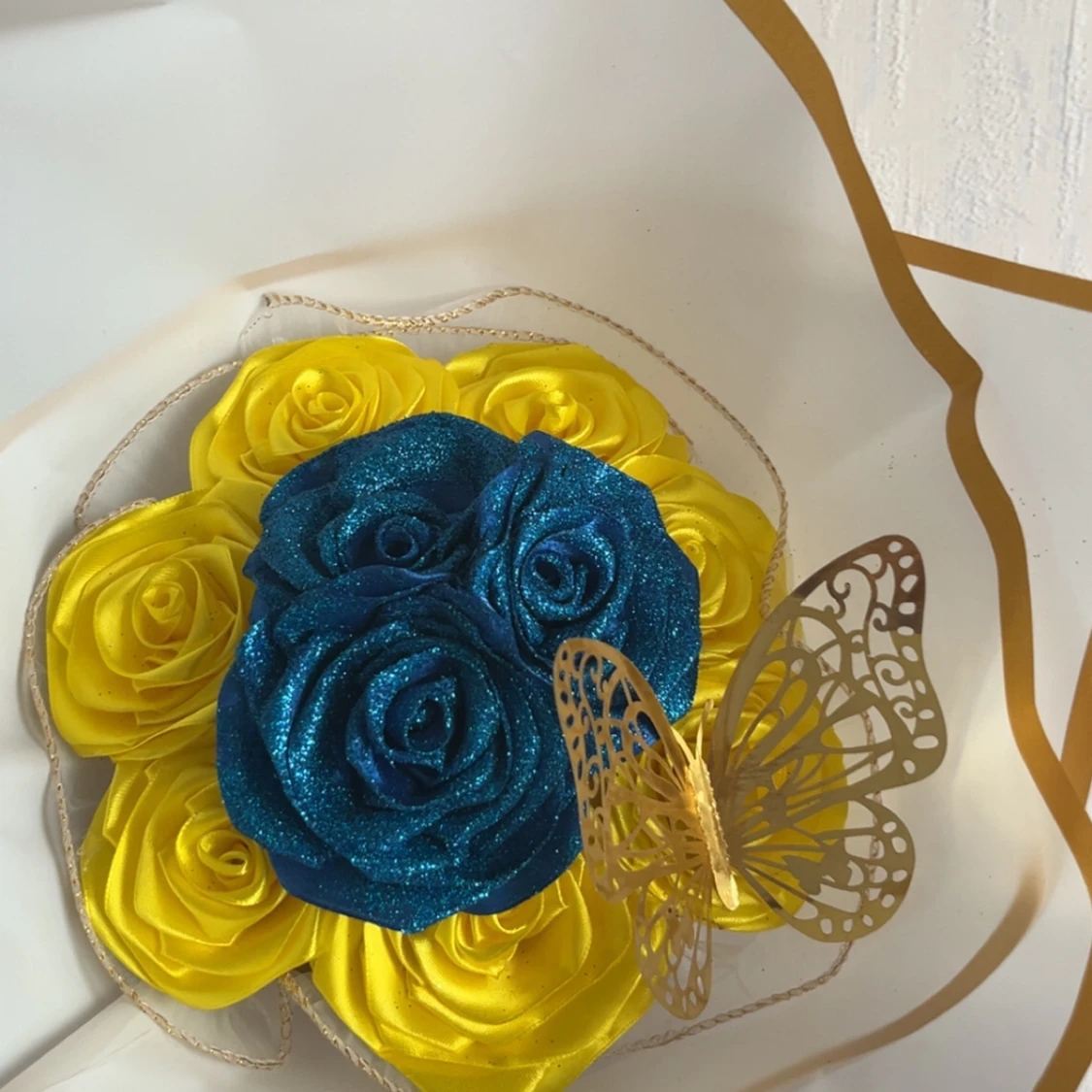 Blått och gult ros-armband med fjäril
